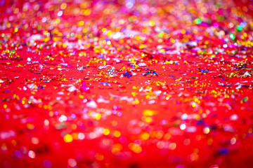 Gold or silver plastic laces cover on the red carpet. Red glitter texture abstract background.