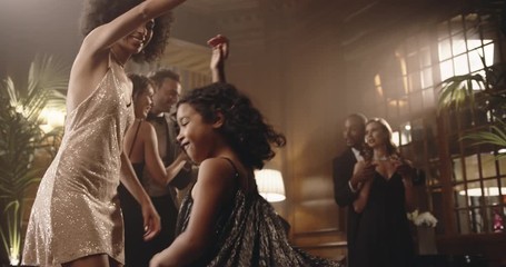 Mother and daughter having fun at gala night. Woman dancing with her girl at party. Girl and woman circling.
