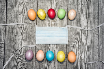 Three colored yellow easter eggs laying in medical mask.