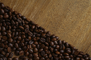 Coffee beans on wooden table with copyspace for text. Selective focus.