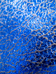 Metallic and electric blue fabric with shiny reflective cracked surface