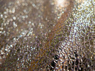 rich metallic gold foiled fabric background with shinny reflective cracked surface