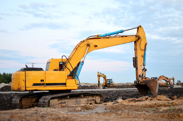 Large tracked excavator on a construction site. Road repair, asphalt replacement.  Loading of stone and rubble for its processing at a concrete factory into cement for construction work.