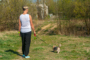 Młoda kobieta na spacerze z psem w lesie podczas kwarantanny - obrazy, fototapety, plakaty