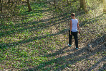 Młoda kobieta na spacerze z psem w lesie podczas kwarantanny
