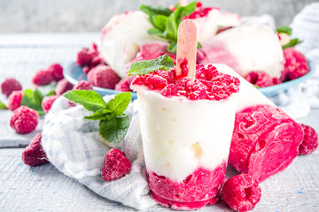 Sweet and tasty diet summer dessert. Homemade raspberry yogurt popsicle with fresh raspberries and mint. Healthy ice cream recipe. Wooden white background copy space