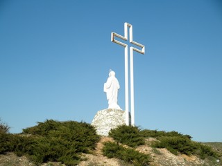 Monument to the victims of the Holodomor in the form of a sculpture of the Holy Mother of God with a cross on the top of Kremyanets Mountain, Ukraine