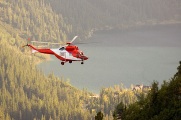 Fototapeta na wymiar Ratownicy górscy ratujący turystę przy pomocy helikoptera w górach Tatrach