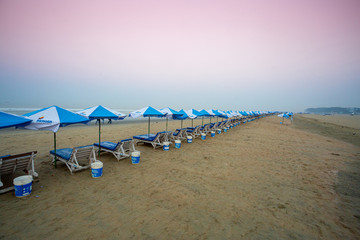 Bangladesh – February 22, 2020: Row of sunshade and deck chairs on Cox's Bazar Beach in Bangladesh.