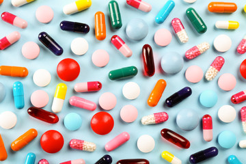 Flat lay composition with bunch of different colorful pills scattered over the table. Pile of...