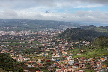 Landscape of a colorful town seen from a viewpoint in the mountain with green hills in Tenerife
