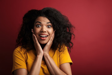 Image of brunette african american woman looking at camera in surprise