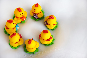 Easter minimalism concept, top view. Close up Group Easter chickens on white background. Yellow beautiful Easter decor of chickens on selective focus with copy space for text.
