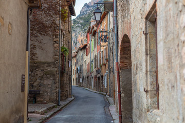 A narrow street with some color houses in a medieval town of France