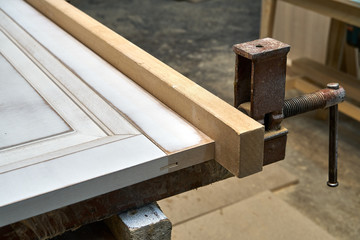Fototapeta na wymiar MDF cabinet door. Joinery. Gluing and clamping MDF cabinet door in workshop. Furniture manufacture