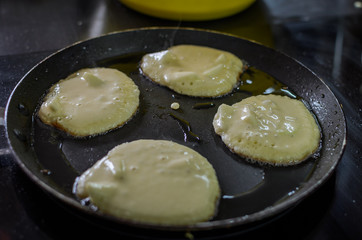  Pancakes are fried in a pan on an induction stove