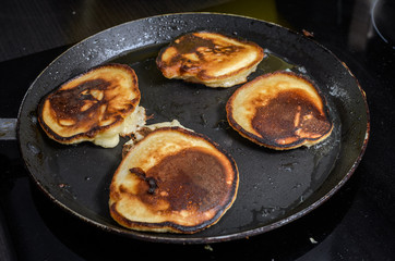 Pancakes are fried in a pan on an induction stove