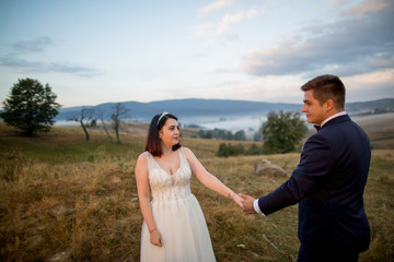 Beautiful wedding couple posing outdoor in park