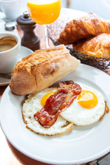 Breakfast with coffee and croissants in a basket on table