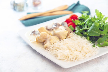 Pieces of chicken fillet cooked in a cream sauce with mushrooms and lemon juice, served with rice.