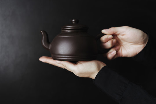 Still life details in the home interior of a living room. Sweaters and a cup of tea with steam on a tray on the coffee table. Breakfast on the sofa in the morning sun. Cozy autumn or winter concept.