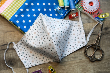 Obraz premium Handmade diy fabric facemask produced at home on a sewing machine, because of the shortage of protection facemasks due to the coronavirus outbreak pandemic.