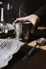 Still life details in the home interior of a living room. a towel and a cup of tea with steam on a tray on the coffee table. Breakfast on the sofa in the morning sun. Cozy autumn or winter concept.