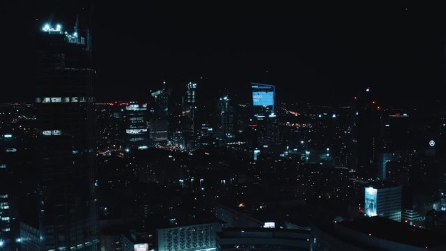 Drone flight between buildings in the city centre of Warsaw at night.