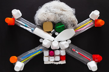 Concept of environmental pollution with plastic waste. Top view of a jolly roger or skull and crossbones symbol made with different plastic objects.