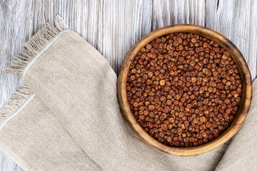 Raw gray peas in round wooden bowl on light wood. Organic healthy diet food. Traditional Latvian product.