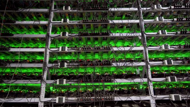 Cryptocurrency mining equipment on large farm. ASIC miners on stand racks mine bitcoin in server room. Blockchain techology application specific integrated circuit. Slider camera.
