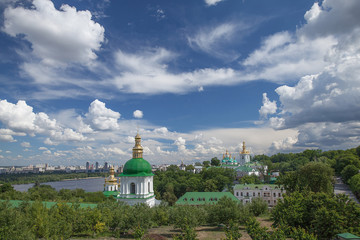 Fototapeta na wymiar View of the Kiev Pechersk Lavra in the spring against a blue sky with white clouds. Kiev, Ukraine