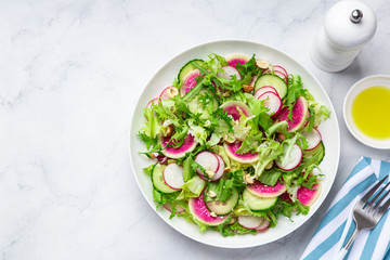 Fresh watermelon radish and  cucumber salad on white plate