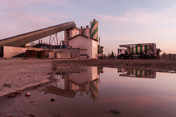 Industrieanlage im Sonnenuntergang mit LKW und Spiegelung.