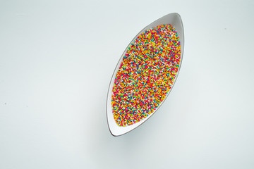 Colourful Sugar sprinkles, decoration for cake, ice-cream and cookies. Top view, Flat lay on white background. Copy space.