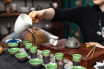  Chinese tea ceremony. Girl pours tea drink into cups.