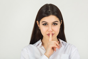 beautiful young woman in a white shirt on a white background with hand gesture