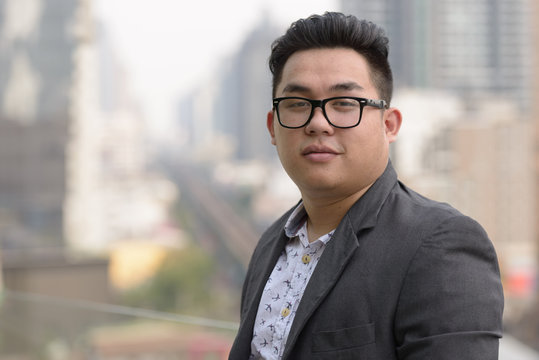 Young Overweight Asian Businessman Wearing Eyeglasses In The City