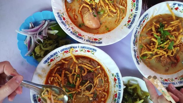 Eating Kaosoi Thai food Northern Thailand Chiang Mai herb and coconut milk noodle