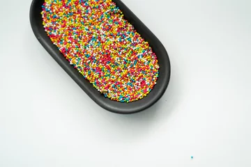  Colourful Sugar sprinkles, decoration for cake, ice-cream and cookies. Top view, Flat lay on white background. Copy space. © ellinnur