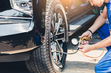 The abstract image of the technician metering the tire air pressure level of the vehicle. the...