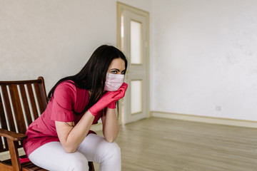 female doctor in medical mask sitting after hard work day