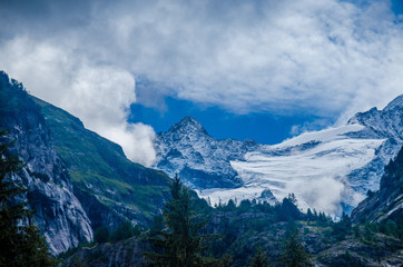Mountain landscape, snowy mountain peaks.
Mountain, coniferous forests surrounded by mountains.
Summer alpine village. Alps mountain range.
Village in the mountains in the summer.
