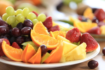 Fruit salad plate with orange slices, pineapple slices, pear slices, grapes, strawberries. Healthy diet lifestyle. Vegetarian. Weight loss. Vitamin boosts immunity during self-quarantine