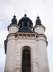 Fototapeta premium Old stone Armenian church in the form of a tower with cross against the blue sky. Lviv, Ukraine.