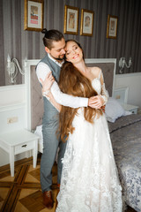 Sweet newlyweds posing in hotel room. The tenderness of a loving couple.