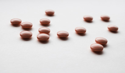 scattered red pills on a white background
