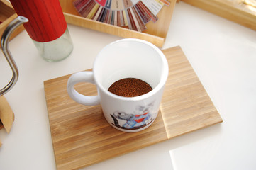 Brewing coffee in mug. Freshly ground coffee in a cup top view