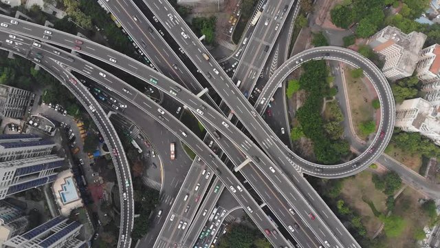 Cinematic top-down aerial shot of large junction in Chinese city, many flyover span above Guangzhou Middle Avenue. Camera turn while looking straight down.