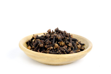 Closeup cloves on wooden bowl – isolated on white background